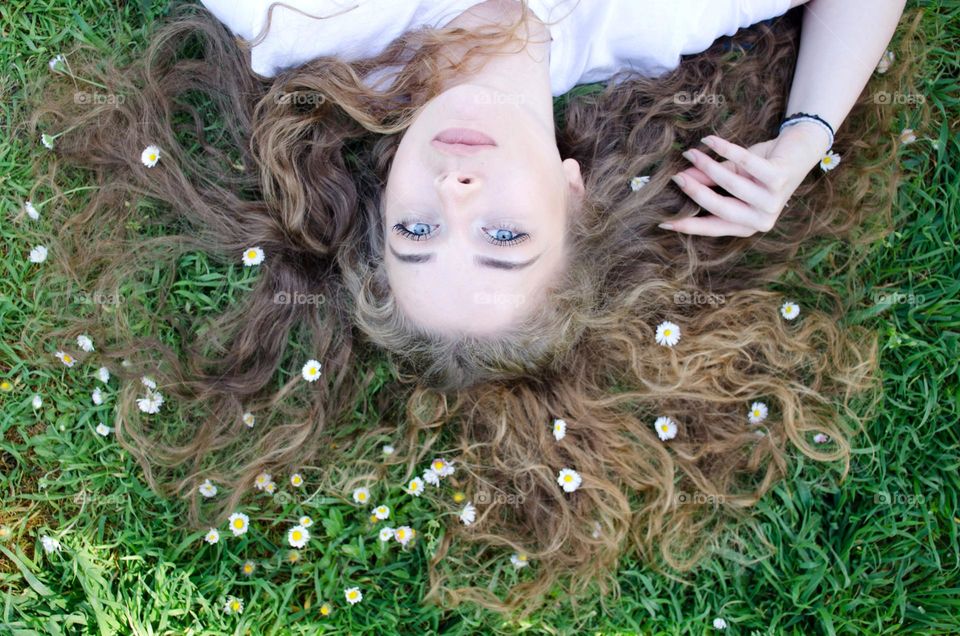 Beautiful Young Girl on Background of Daisies