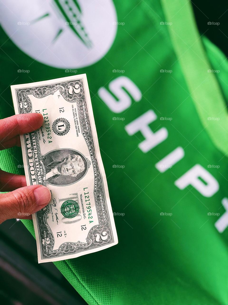 Green money with a green Shipt bag, Shipt shopper gets a tip on cash, green United States money, Shipt shopper gets tipped in cash, Shipt shopping service, two dollar bill for a tip, shopper gets a two dollar bill for a tip 