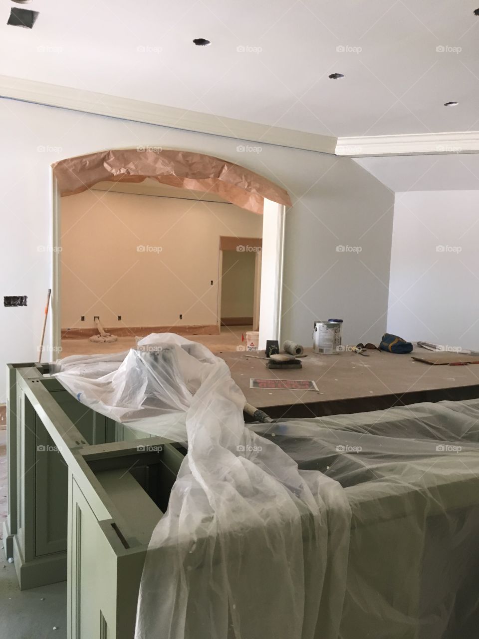 A picture of the kitchen island which is covered up with plastic wrap to protect it while we paint 