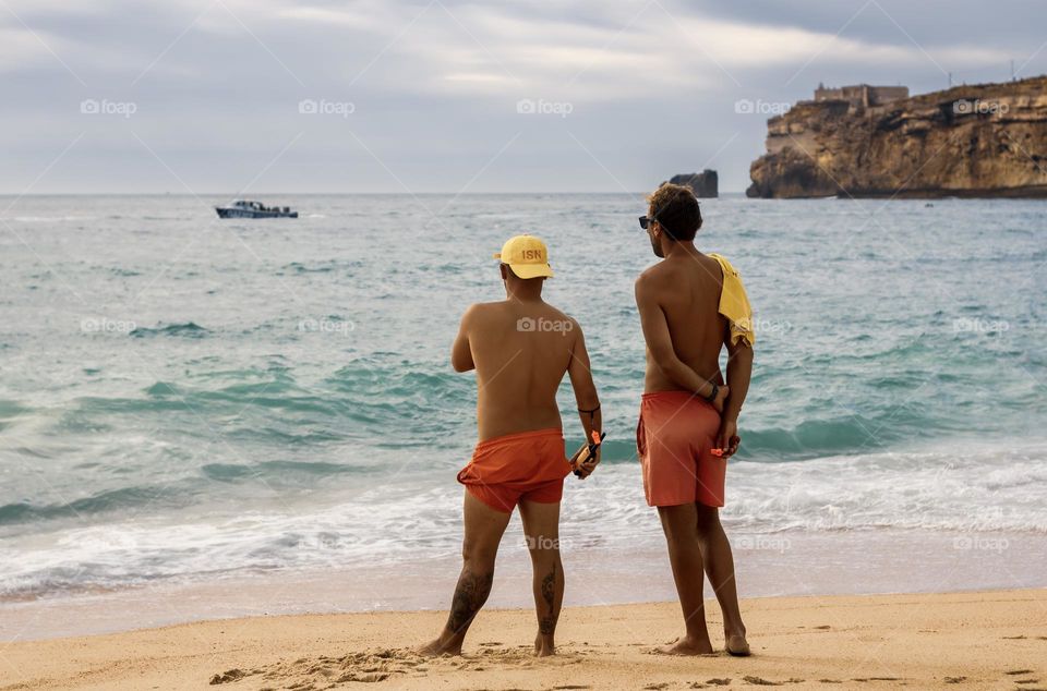 2 lifeguards patrol Praia da Nazaré in Portugal 