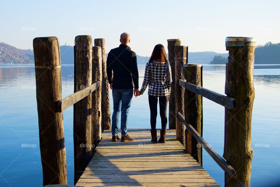 Rear view of a couple standing on the pier