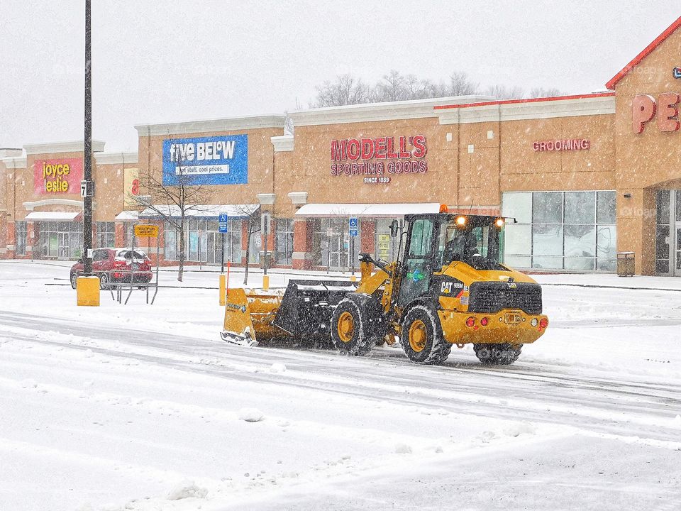 It’s snowing! Yellow parking lot snow plow... 