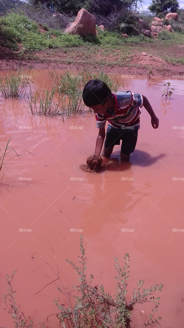 child playing in dirty water