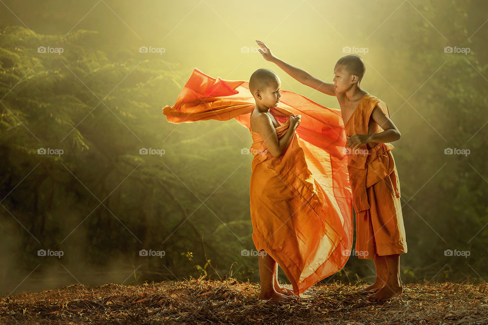 Novice buddist monk dressing.. Novice buddist monk dressing at the sunset.