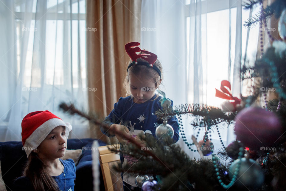 Little sisters with German shepherd puppy near Christmas tree 