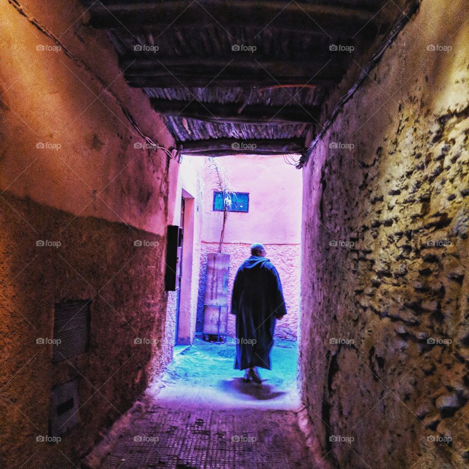 Colorful narrow street with local man in the Medina of Marrakech