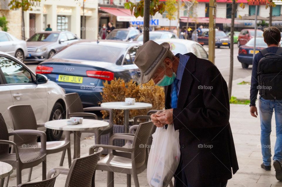 An elderly man counts change after a visit to the store