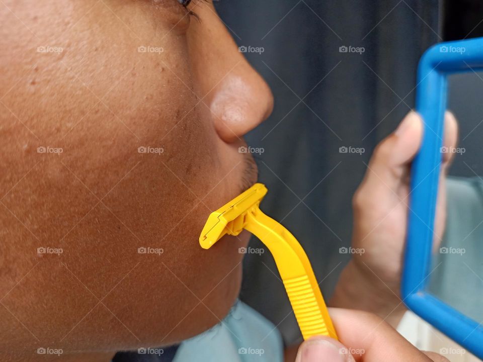 Man is shaving his mustache