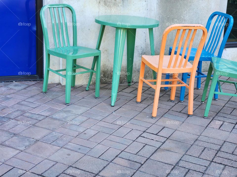 colorful chairs and table on brick terrace