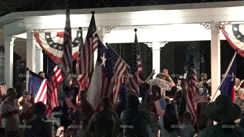 Children holding flags at the Galveston Beach Band concert during The National Anthem.