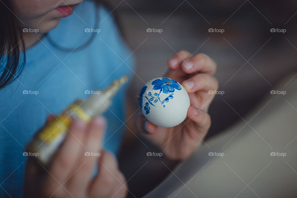 Little girl painting the Easter egg