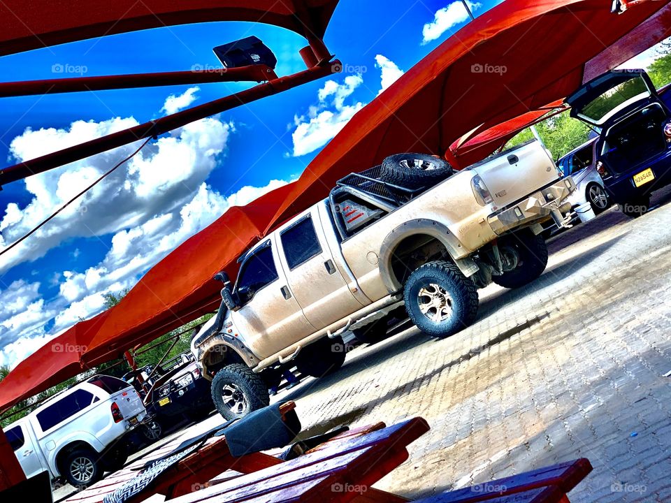 A big pick up truck at the car wash on a bright sunny day after a long day.