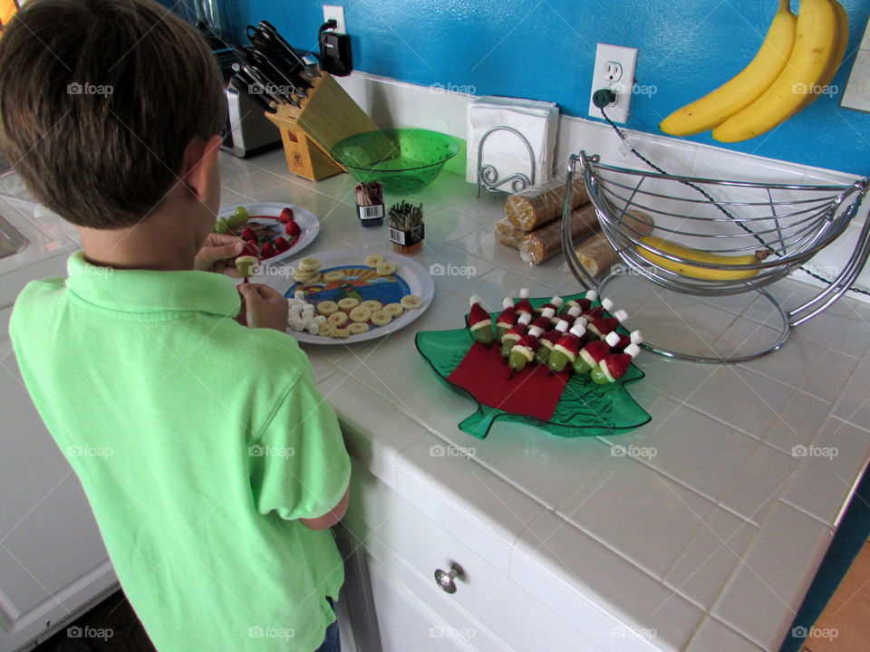 Child preparing Santa Grinches fruit snack