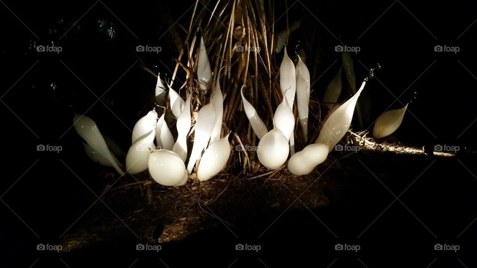 ghostly white glass figures in the garden, glass art sculpture