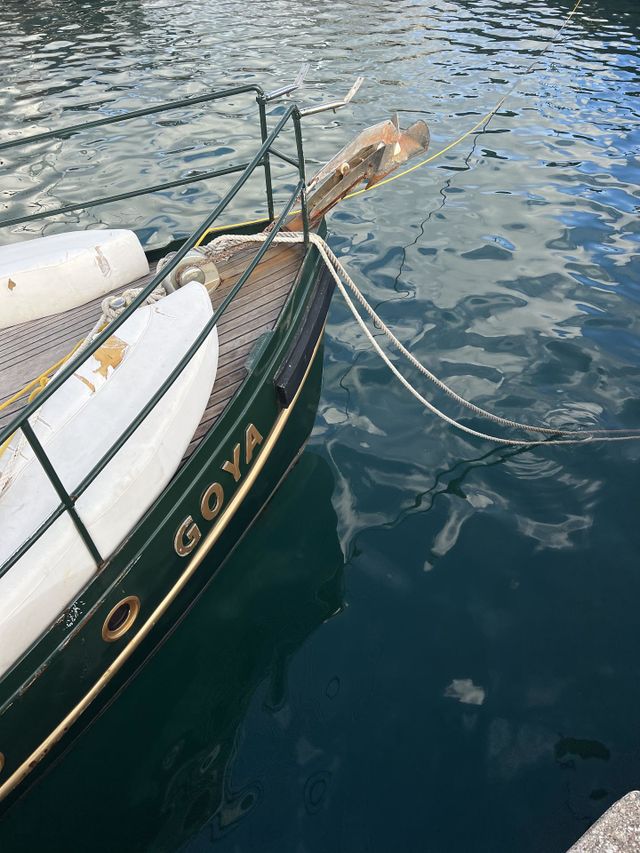 Blue sea and deep green and gold vintage style boat