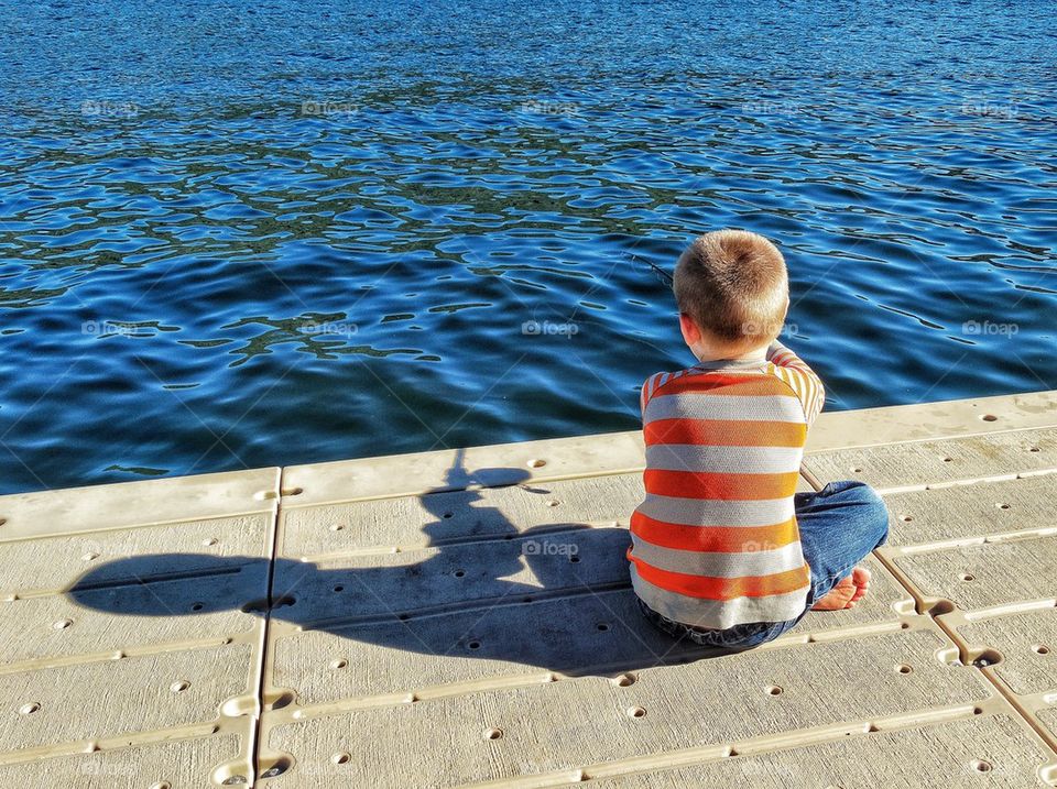 Young Fisherman. Young Boy Fishing By Himself
