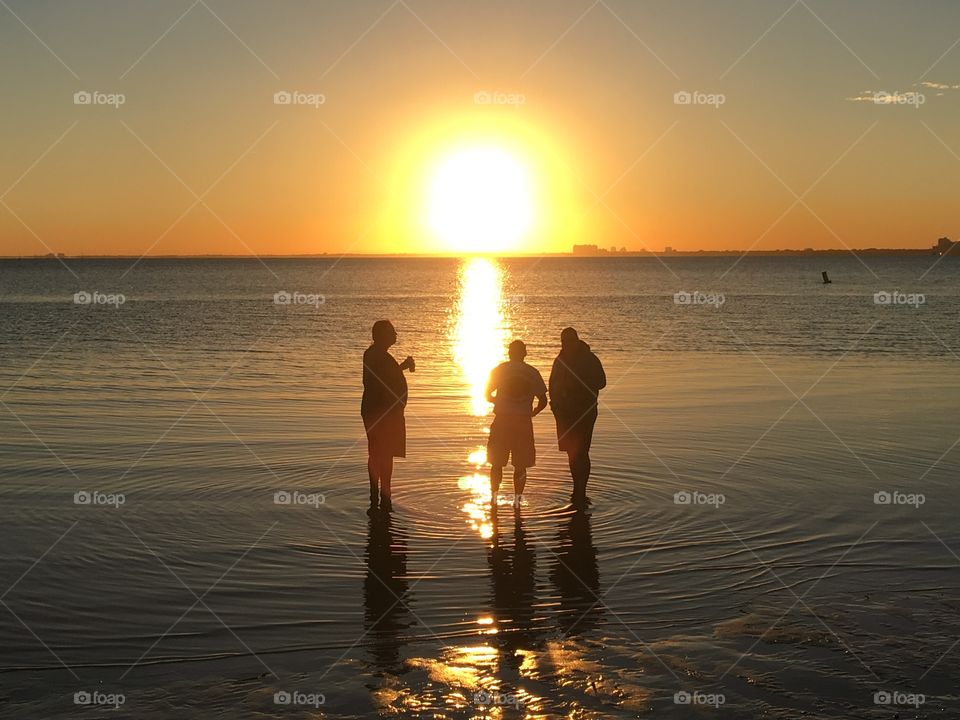Silhouettes of men at the beach during sunset