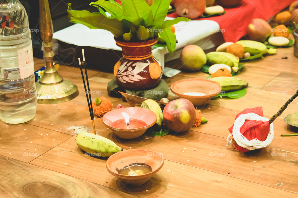 Selective focus. Diwali puja or Laxmi puja set up at home. Oil lamp or diya with crackers, sweet, dry fruits, indian currency, flowers and statue of Goddess Laxmi on a festival Diwali night.