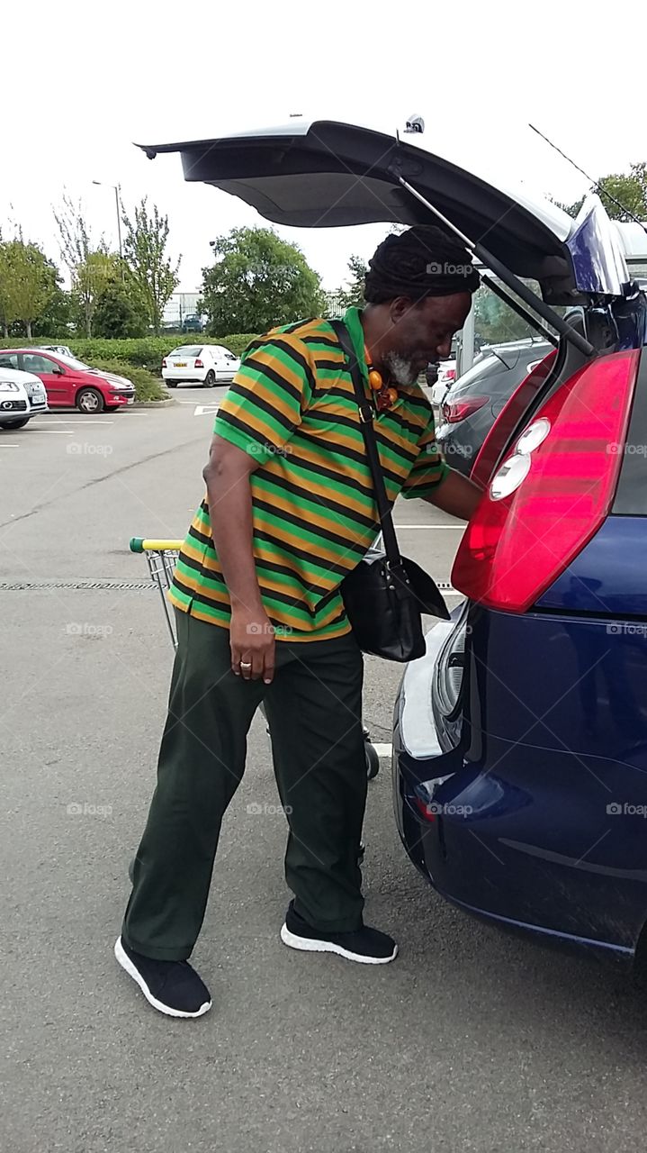 A Man unloading his shopping into his car