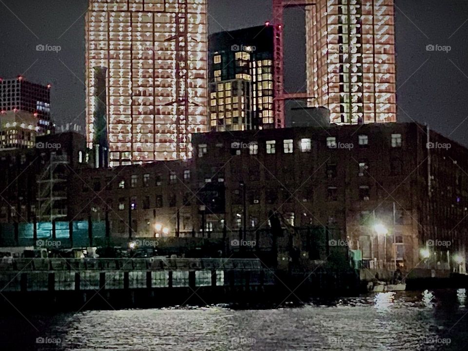 A monumental construction site illuminated at night on the “Greenpoint, Bklyn” side of “Newtown Creek”, an ocean inlet of the “East River” that divides LIC, Queens & Greenpoint and is connected via the “Pulaski Bridge”. 2022. Hypnotic Productions