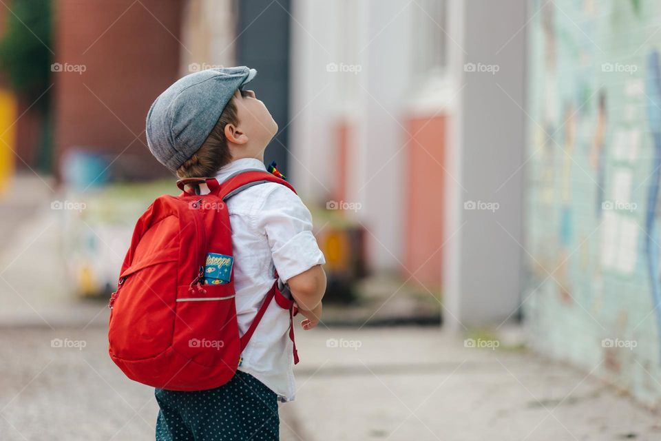 litle boy ready for school looking up