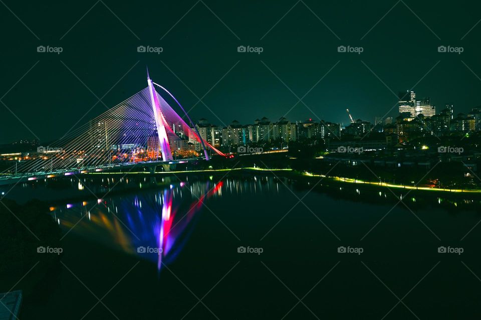 Night view from the highest Floor. Selangor Malaysia. Bridge. Lakes. light. Colourful bridge in putrajaya Malaysia. night sky clouds in city, cars bikes and truck buses are passing by.