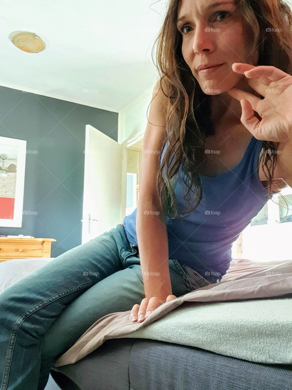 A picture of a woman sitting on a bed