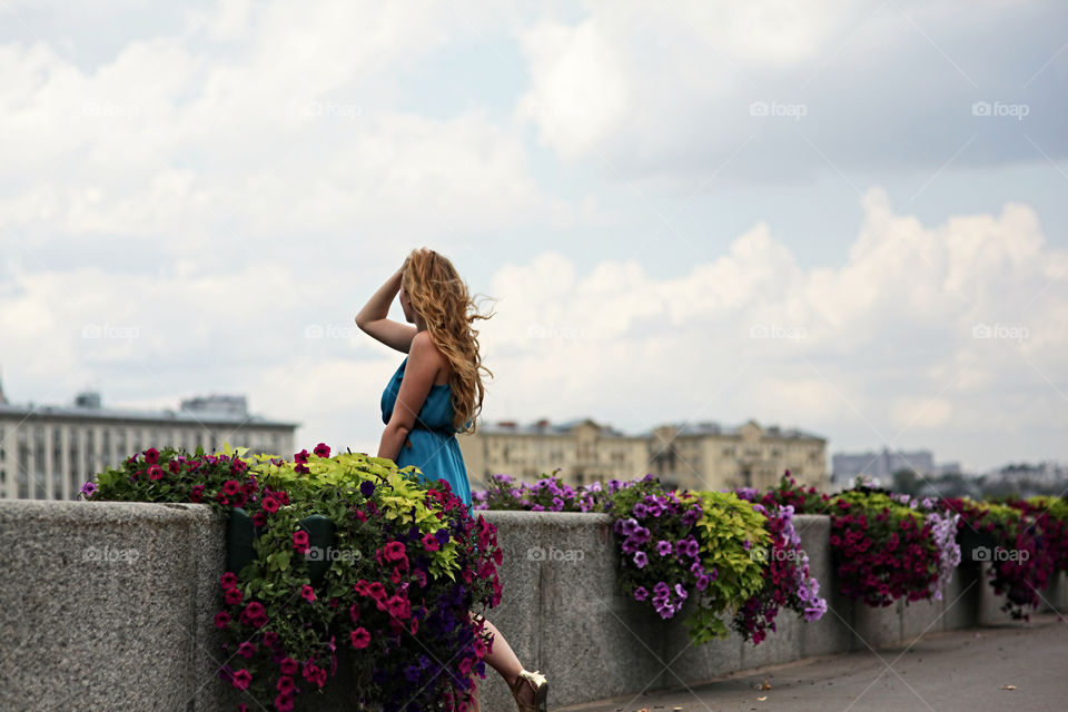 Women standing besides flowering plant