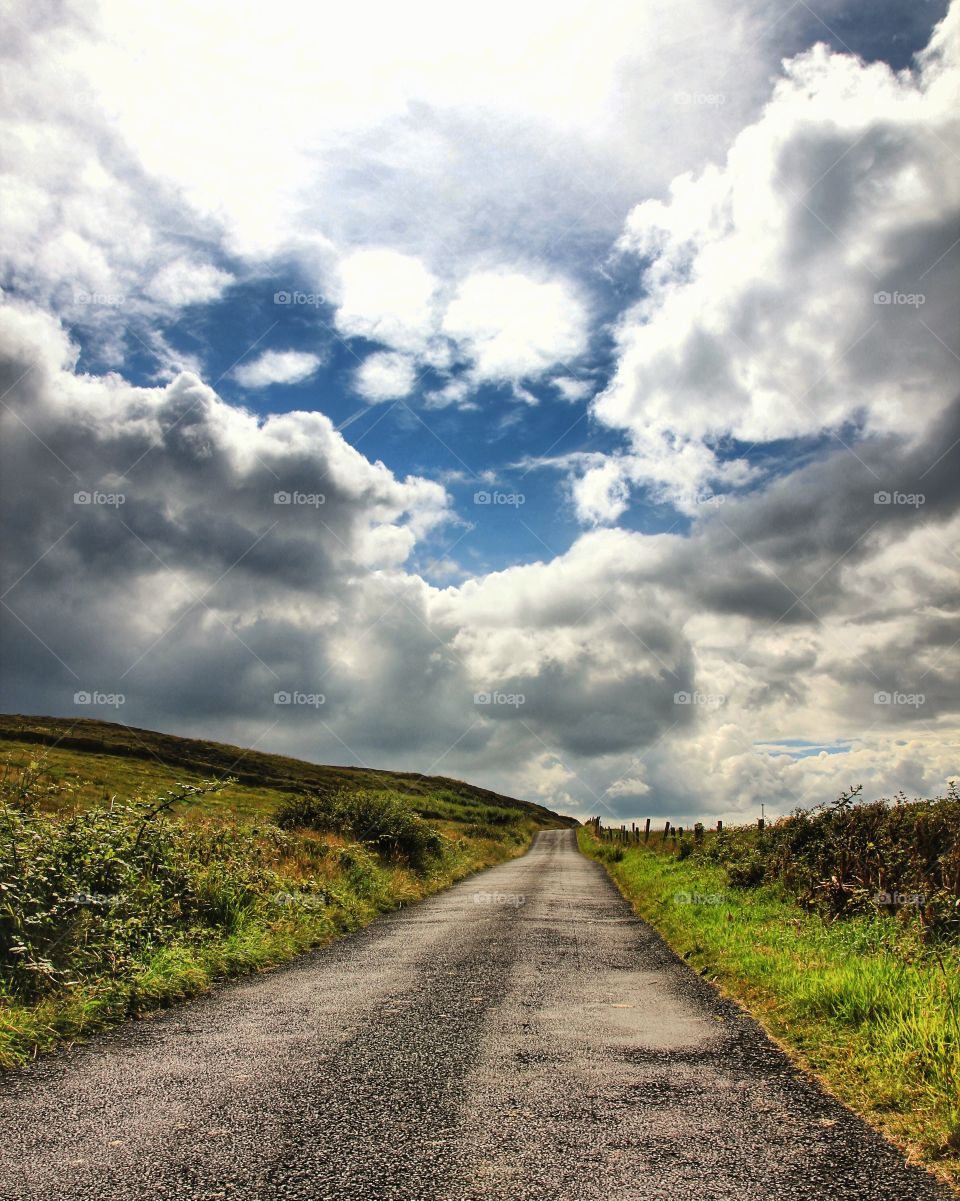 Empty road against cloudy sky