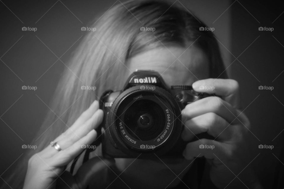black and white self portrait holding the camera up to my face taking the photo with a nikon camera in the mirror