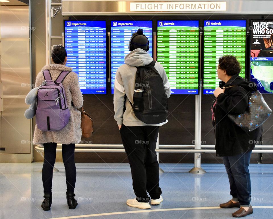 People looking at the Arrival Departure Board at the airport