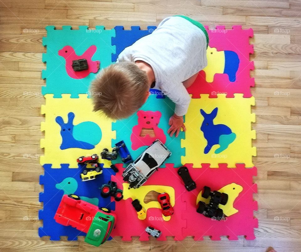 Todler playing ON colourful Kids puzzle carpet