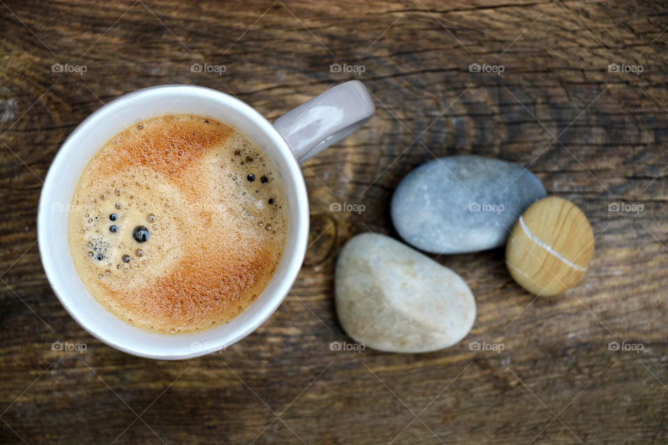 cup of coffee on a wooden background with zen cairn stones