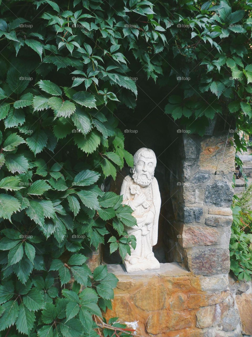 sculpture on a background of green leaves