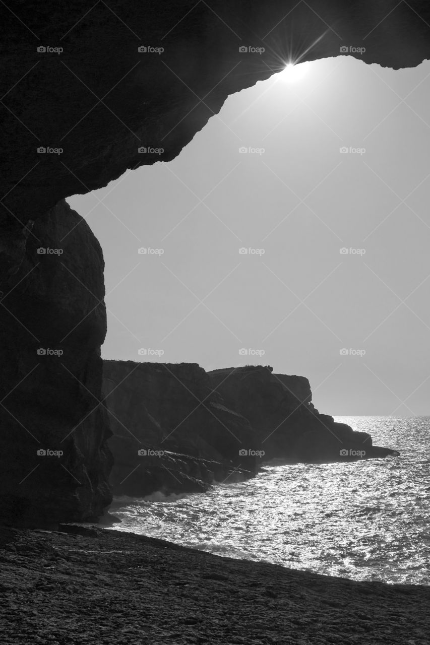 Silhouetted cliff and shore on a sunny day