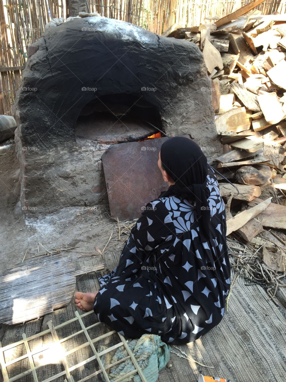Egyptian woman baking traditional bread in mud oven 