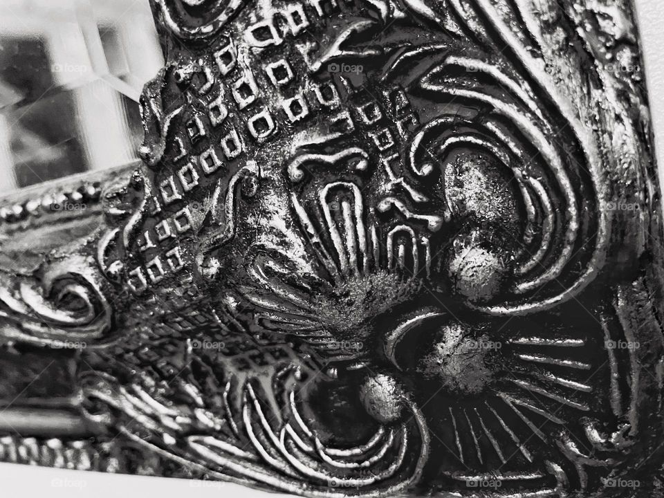 Close up of mirror ornamentation in black and white. Detailed and textured surface