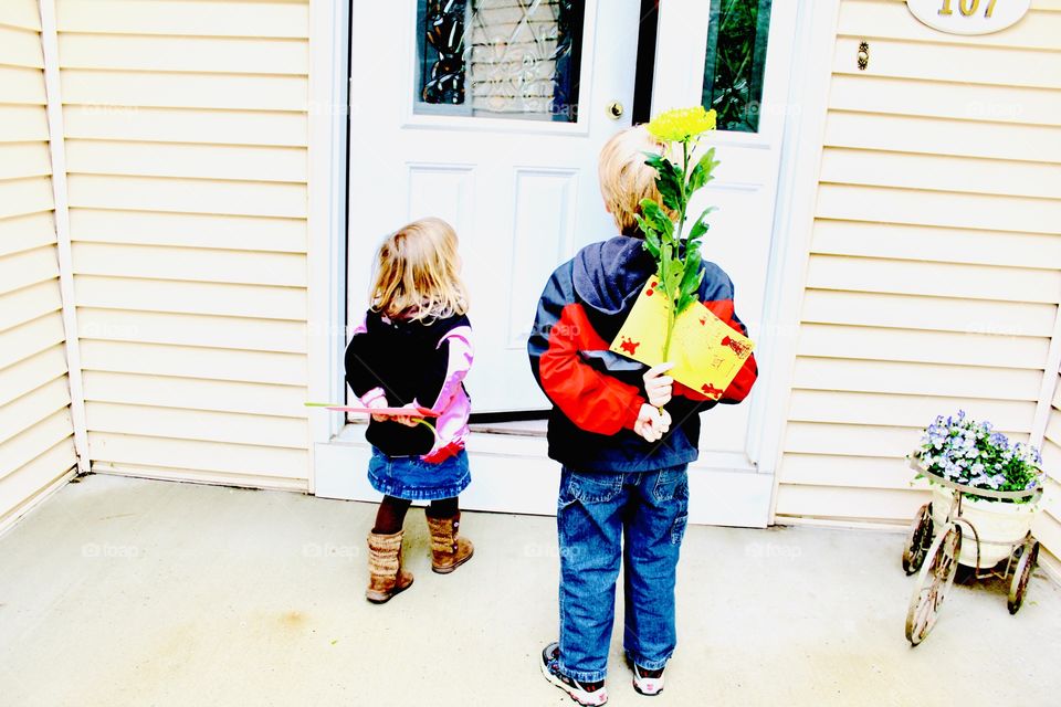 Darling colorful photo of two kids bringing a gift, card, and flowers to their Grandma!! 