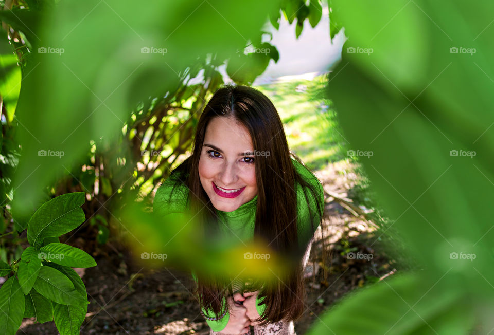 Portrait of cute young girl over leaves surrounding the frame.