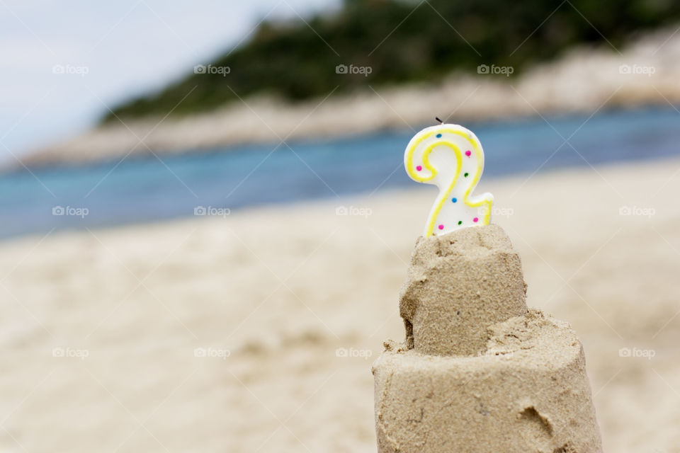 sandy birthday cake. birthday cake made of sand with candle number two