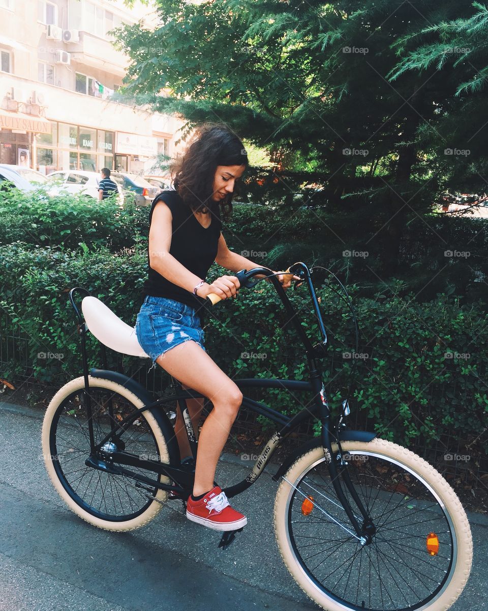 Teenager girl on bicycle at town road