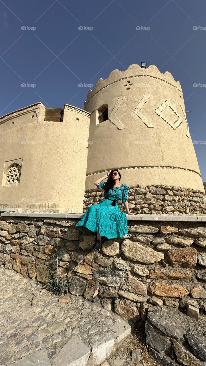 Curly haired girl next to the historical castle