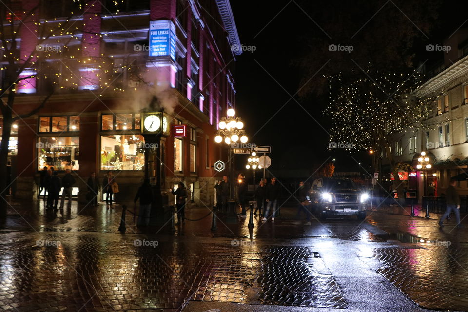 Night in the city, street lights reflection on the wet cobblestone 