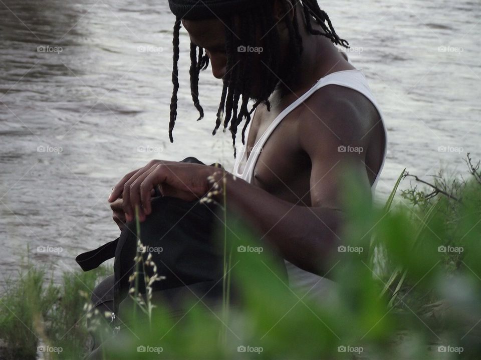 a man open a bag beside the river