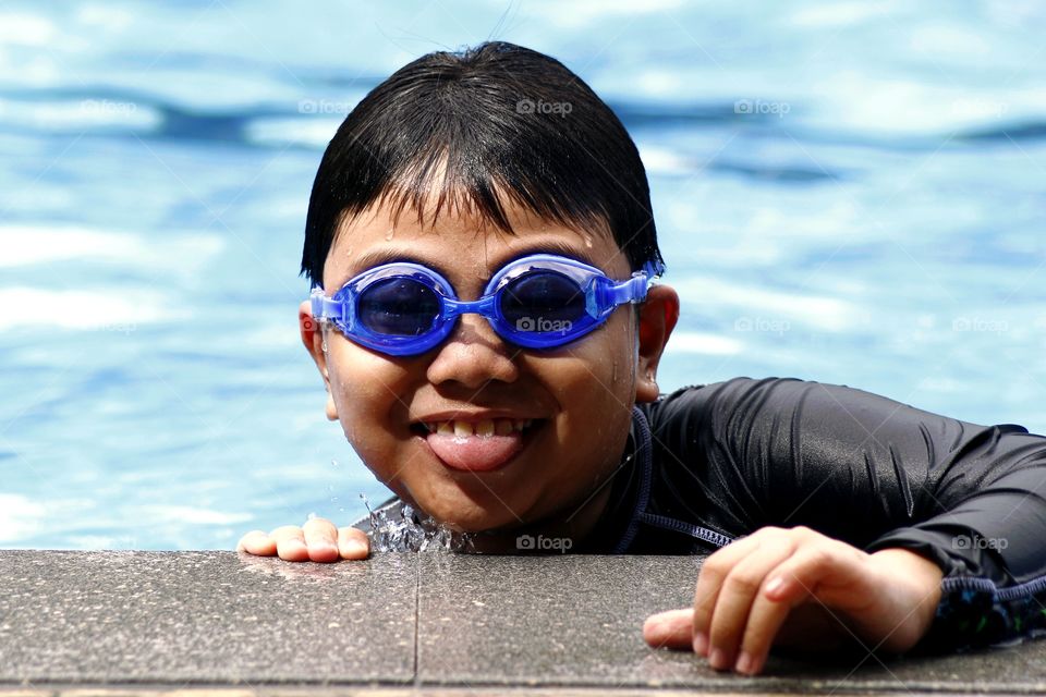 young boy with goggles in a swimming pool