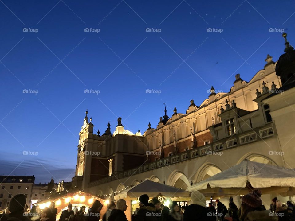 Kraków city at night during Christmas time. Famous landmarks and Christmas tree. Sightseeing the city at night. Crowded evening on Christmas market.