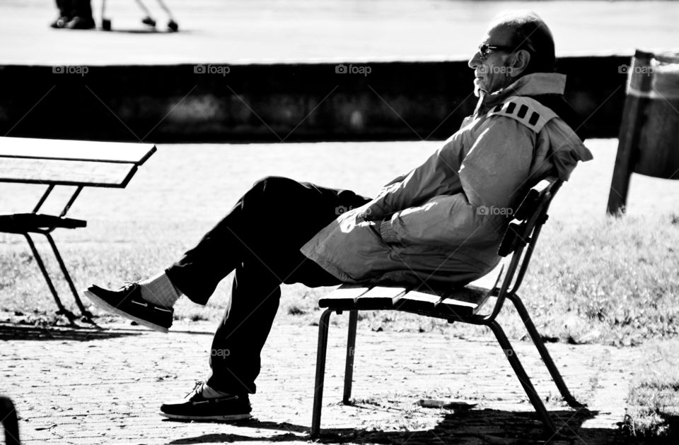 silhouette of elderly man sitting on a bench