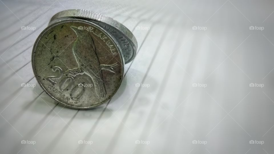two rupiah coins are placed on the book