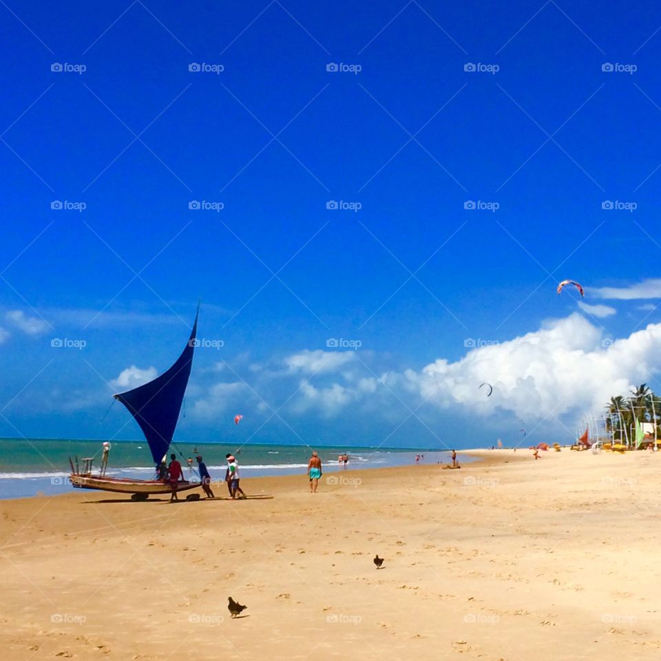 Relaxing on the beach sand, watching the boat getting ready to go to the sea! / (Cumbuco Beach, Brasil). Relaxando na areia da praia, observando o barquinho se preparando para ir ao mar!