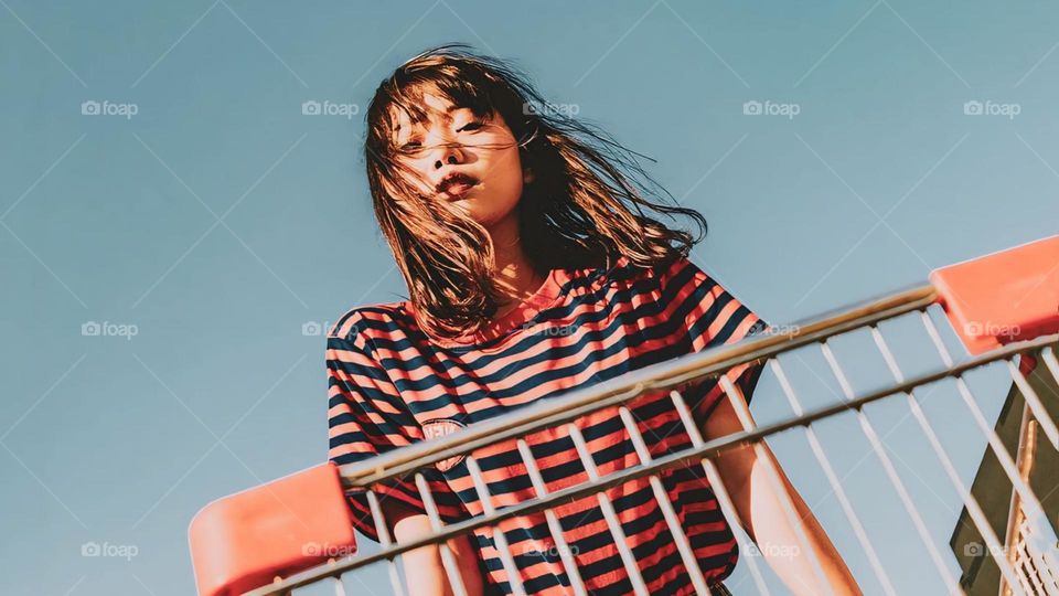 Portrait of cute young woman in front of shopping trolley